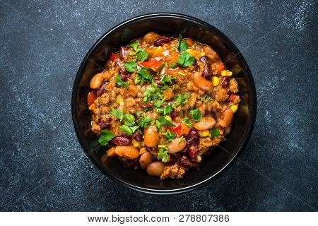 Chili Con Carne From Meat, Beans And Vegetables On Black Stone Table. Traditional Mexican Food. Top 