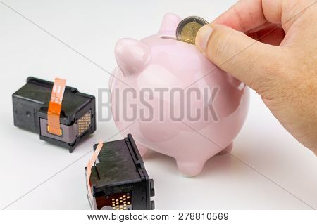 Benon, France - January 15, 2019: Closeup On Hand Holding A Coin Next To A Piggy Bank And Two Canon 