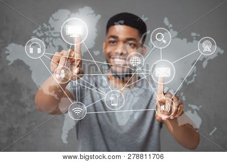 Global Connection. Cheerful African-american Man Pushing World Map Interface On Virtual Screen