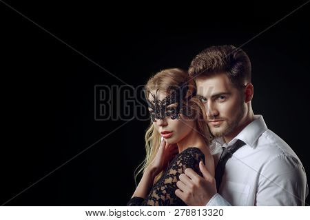 Caucasian Blonde Woman Portrait With A Lace Black Mask Teasing An Elegant Man As In The Movie Fifty 