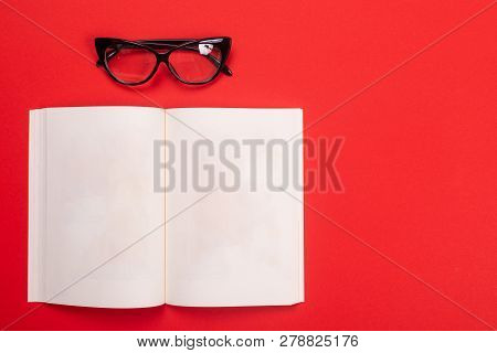 Noteboook And Glasses Isolated With Copyspace On Red Background