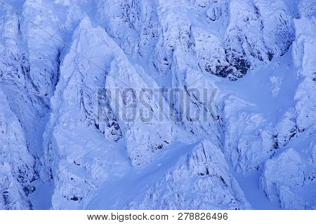 Bucura II Peak, 2372m. Winter alpine landscape in National Park Retezat, Carpathians, Romania, Europe. Snow covered moutains scenery