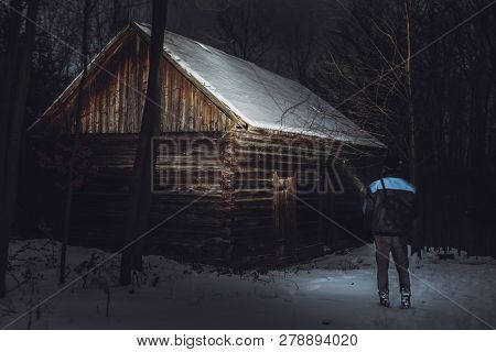 Man (photographer) Standing In Front Of The Abadoned And Creepy Cottage In Forest In Winter. Man On 