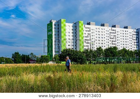 Poznan, Poland - July 10, 2018: Man And Woman Walking Between A Field With Plants On A Sunny Summer 