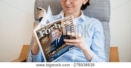 Paris, France - Mar 16, 2018: Young Business Woman Reading The Worlds Billionaires List In Forbes Ma