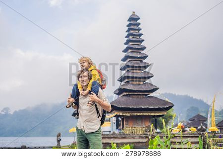 Dad And Son In The Background Of Pura Ulun Danu Bratan, Bali. Hindu Temple Surrounded By Flowers On 