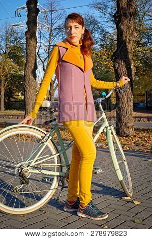 Portrait Of Beautiful Stylish Young Woman, Wearing Yellow Jeans, Pink Cashmere Vest And Sneakers, St