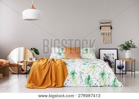 Peach Colored Blanket And Pillow On Bed In Grey Bedroom Interior With Copy Space On The Wall