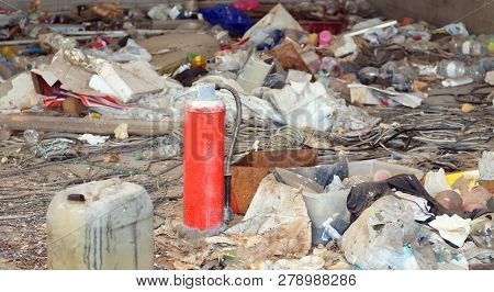 Homeless Shelter With Many Garbage And A Red Broke Abandoned Extinguisher
