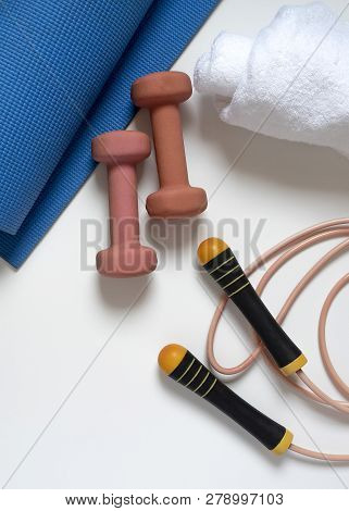 Jump Rope, Yoga Mat, Dumbbells, White Bath Towel, Close-up On A White Background Vertical Frame