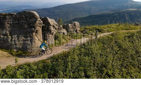 Cycling woman riding on bike in autumn mountains forest landscape. Woman cycling MTB flow trail track. Outdoor sport activity.