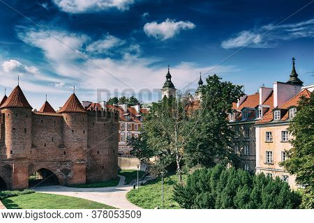 Warsaw, Poland Summer View Of Barbican Or Barbakan Wall And Old Town Houses With Green Trees And Blu