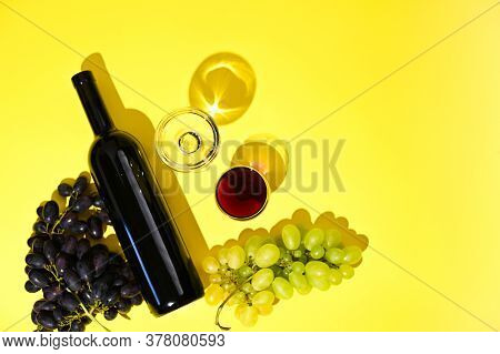Two Glasses Of Red And White Wine, A Bottle, Grapes On A Yellow Background. The Concept Of Italian W