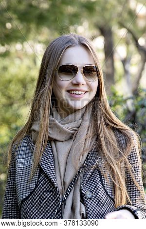 Young Long Hair Woman Model Of Clothes In The Garden In Spring Posing