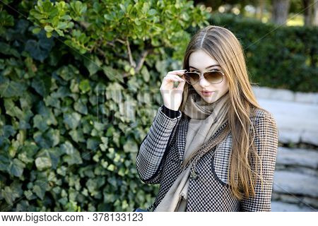 Young Long Hair Woman Model Of Clothes In The Garden In Spring Posing