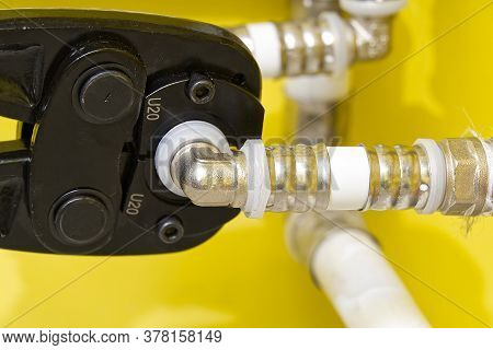 Worker Connecting Alupex Pipes With A Tap. Hand Press For Water Pipes Pex - Al - Pe-x. Plumbing Indu