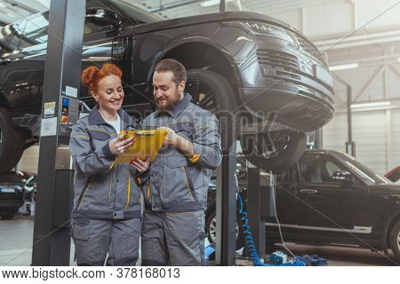 Two Mechanics Repairing A Car