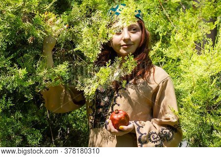 Armenian Young Woman In Traditional Clothes In The Forest With Pomegranate