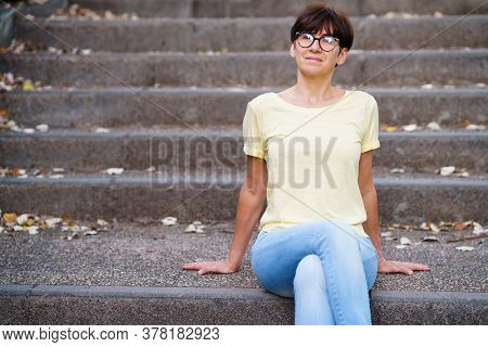 Beautiful Middle-aged Woman Sit On The Street