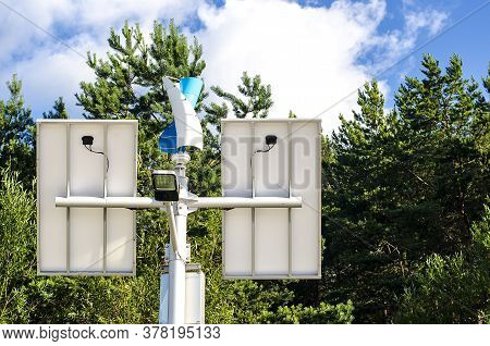Top Of Street Lamp Post With Solar Panels And Wind Turbine.
