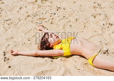 Young Woman Lies In Summer On The Beach. The Girl Lies On The Sand On The Beach. Teenager At Sea. Va