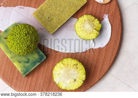 Green Natural Soap From Chinese Orange Or Maclura Fruit And Green Fruit On A Wooden Board, Top View