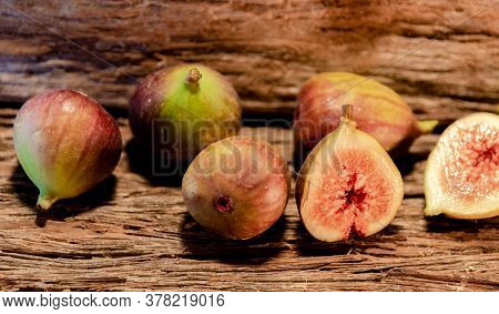 Fresh Figs (ficus Carica) And Halves On Rustic Wooden Background...
