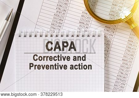 On The Table Are Financial Reports, A Pen, A Magnifying Glass And A Notebook With The Inscription - 