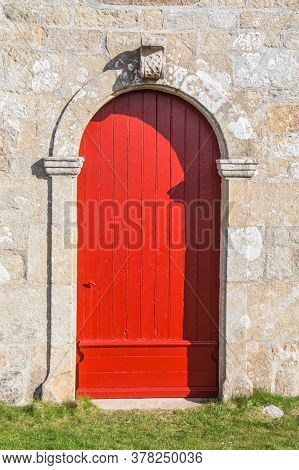 Red Wooden Door Of Notre Dame De Bon Voyage Chapel In Plogoff