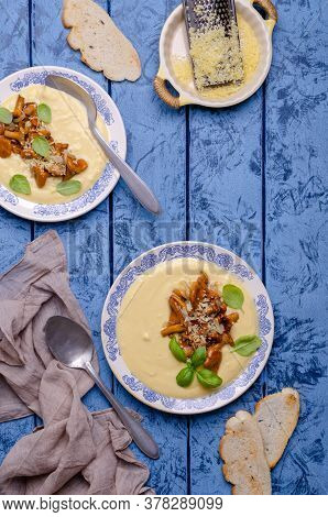 Traditional Polenta With Mushrooms And Cheese In A Dish On A Blue Wooden Background. Selective Focus