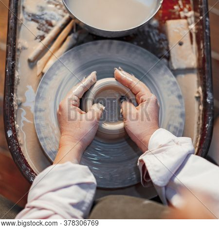 Close Up Of Woman Hands Working On Pottery Wheel With Clay