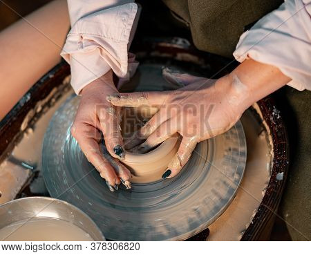 Close Up Of Woman Hands Working On Pottery Wheel With Clay