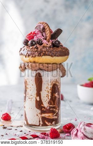 Chocolate Indulgent Frosting Exreme Milkshake With Donut  And Sweets. Crazy Freakshake Food Trend. C