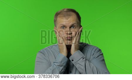 Surprised Funny Comical Man Making Silly Face With Inflates The Cheeks And Looking With Shocked Dumb