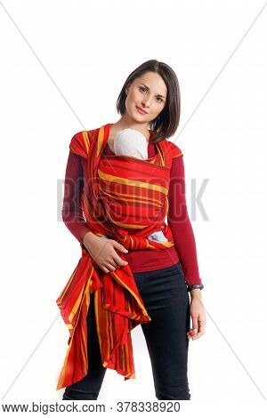 Babywearing Beautiful Young Mother With Baby In Red Woven Wrap Carrier. Free Hands And Active Mother
