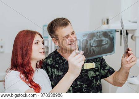 Doctor Dentist With An Assistant Check The X-ray Orthopantomogram. Dental Panoramic Radiography