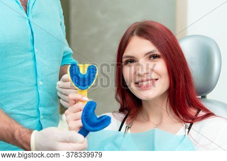 Doctor Orthodontist Shows The Patient The Result Of The Casts Of Her Teeth
