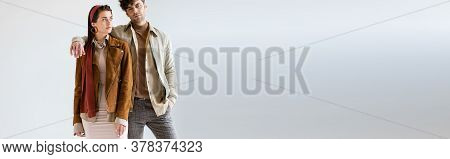 Webside Header Of Young, Stylish Couple In Autumn Clothes Posing On Grey