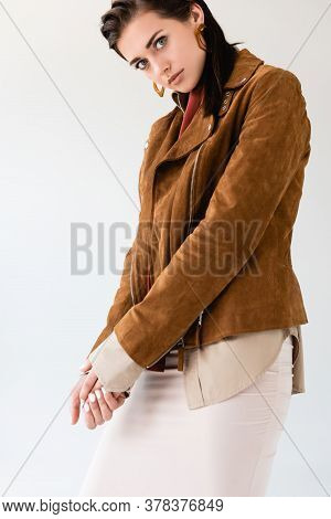 Beautiful, Stylish Girl In Suede Jacket Looking At Camera Isolated On Grey