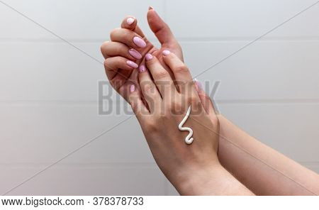 Close Up Of Female Hands With Moisturizing Creme On The White Tile Background. Skincare And Handcare
