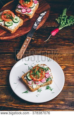 Vegetarian Sandwich With Fresh Sliced Tomatoes, Cucumber And Radish On White Plate
