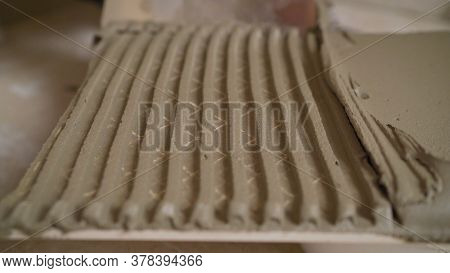 The Master Smears The Tiles With Glue. The Master Tile Smears The Mucilage Solution On The Marble Ti