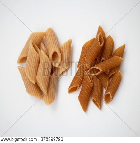 Raw And Cooked Dark Wholemeal Pasta On A White Background