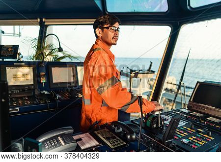 Filipino Deck Officer On Bridge Of Vessel Or Ship. He Is Speaking On Gmdss Vhf Radio