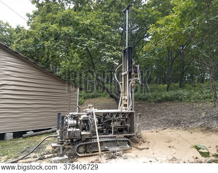 Modern Rotary Drill Rigs Bore Water Well Standing Near A House Under Construction