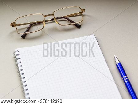 Opened Ruled Note Book With Pen And Spectacle. Selective Focus Of Notebooks, Pens, Glasses Backgroun
