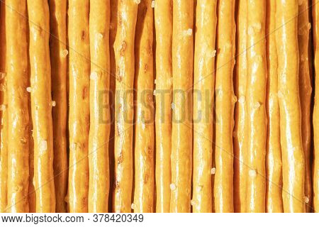 Salty Sticks Line In Row Background. Top View. Snack Texture Background. Salty Bread Sticks For Beer