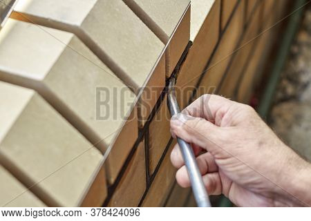 Bricklayer Builds New Fence From Facing Bricks. Alignment Of Inter-brick Joints
