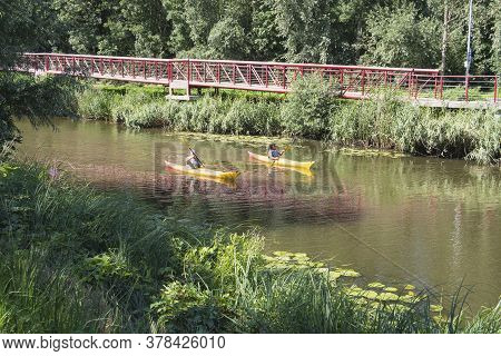 Lokeren, Belgium, July 13, 2020, Man And Woman Are Sailing On The Durme In A Yellow Canoe