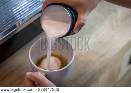 Barista In Cafe Or Coffee Bar Preparing Proper Cappuccino Pouring Milk Froth In A Cup. Waiter Hands 